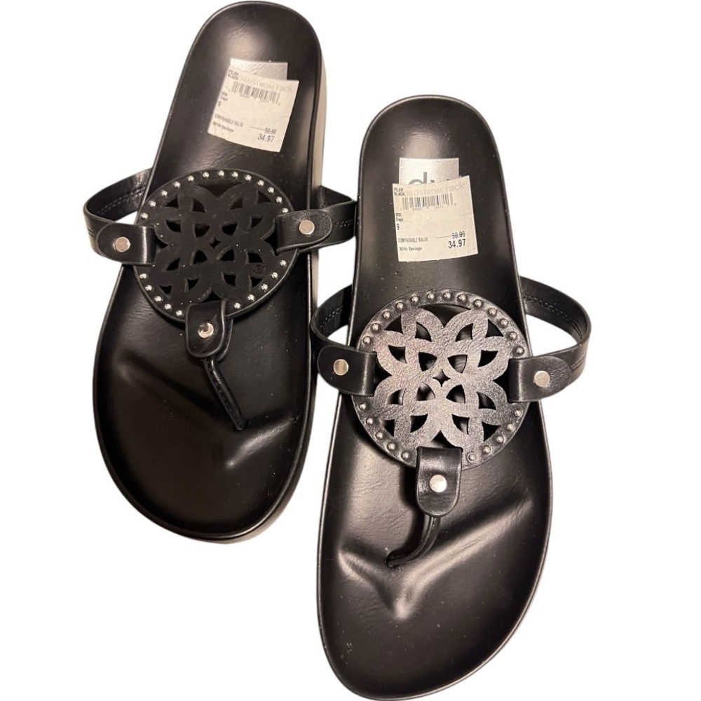 Black leather sandals with silver hardware and decorative cutouts.